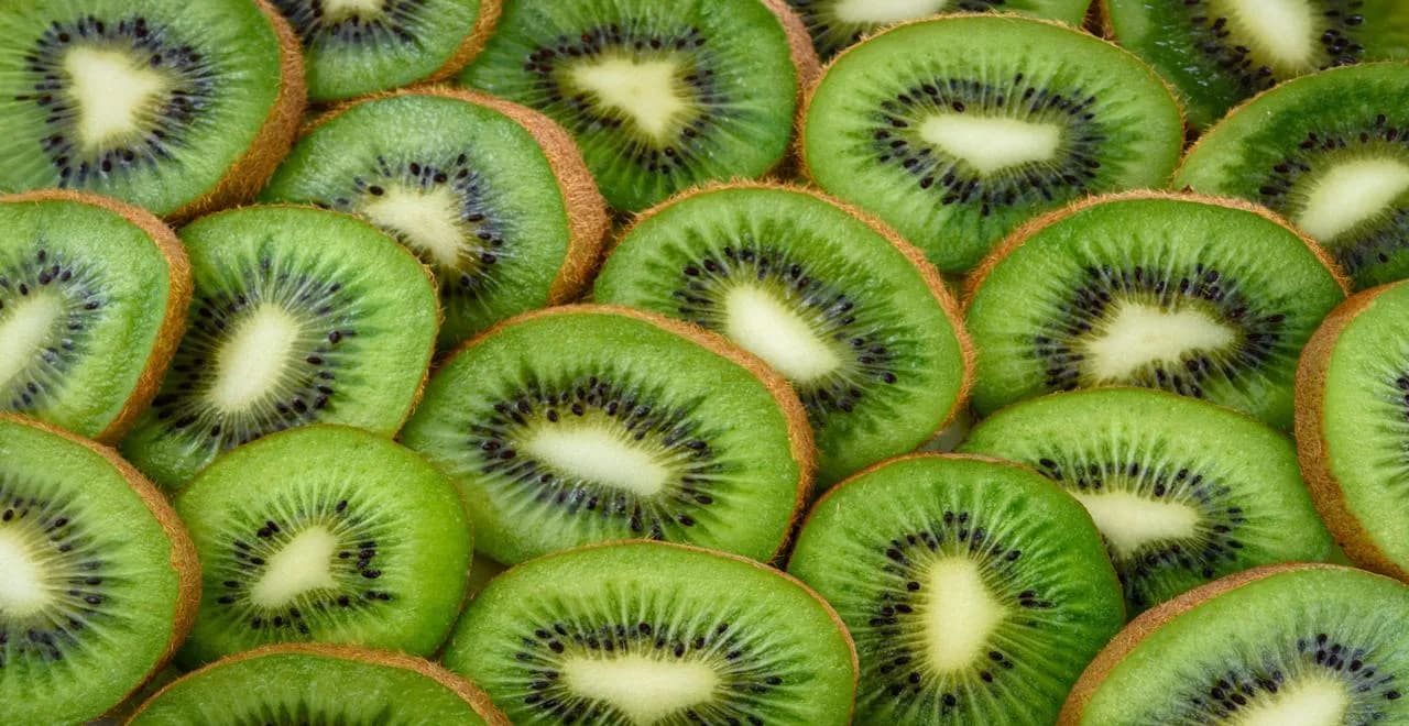 Jardinier taillant un kiwi, démontrant les différentes techniques de taille saisonnière