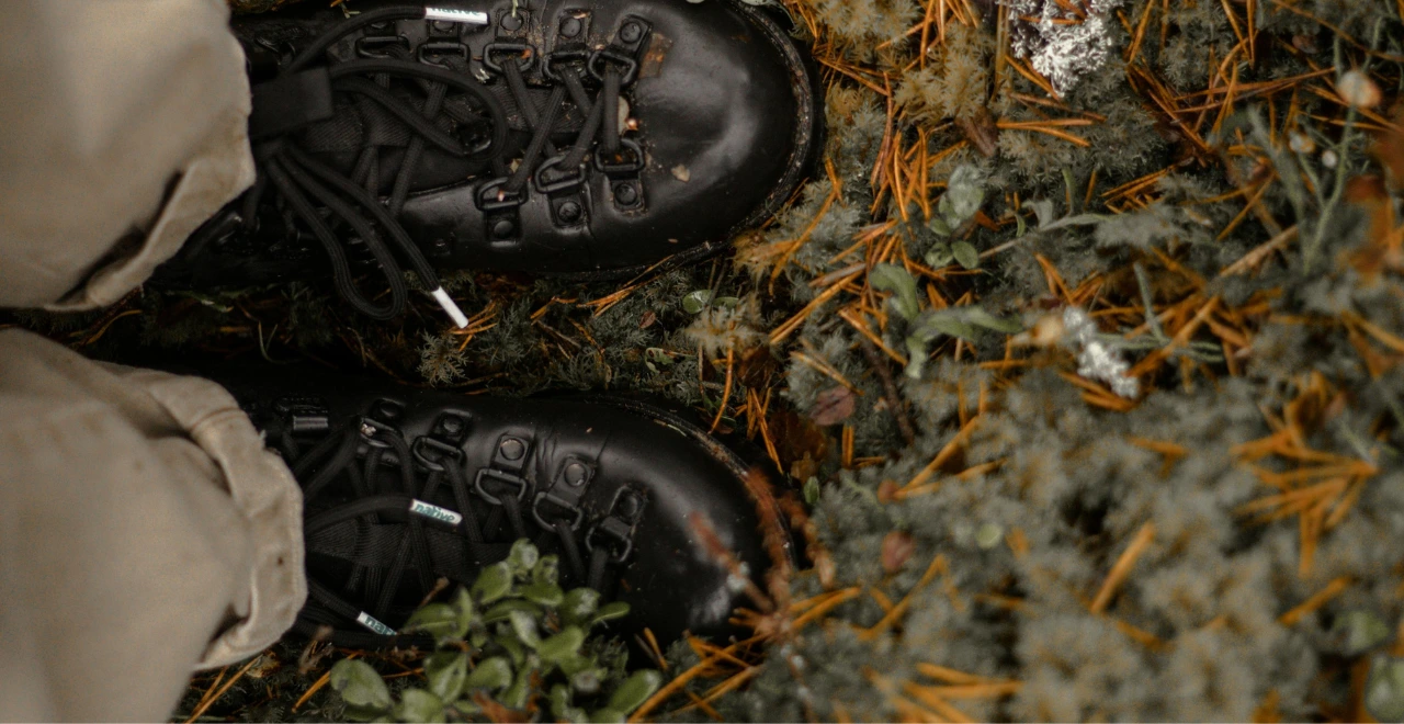 Sol mouillé dans le potager avec des bottes visibles en arrière-plan.